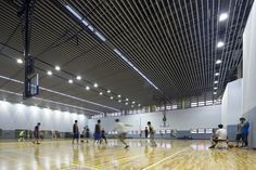 an indoor basketball court with many people playing