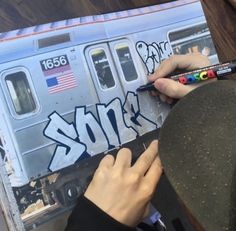 someone is painting graffiti on the side of a train