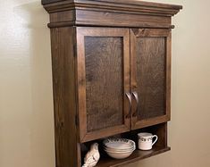 a wooden cabinet with plates and cups on it