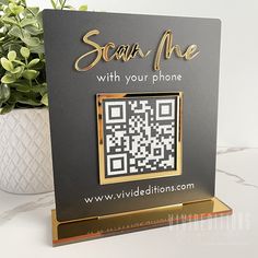 a black and gold photo frame with a qr code on it