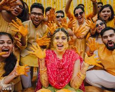 a group of people that are all covered in yellow paint and some have their hands up