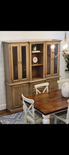 a dining room table with chairs and a hutch in the backround area