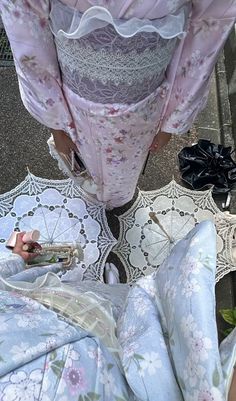 a woman is standing on the ground with an umbrella and some other things in front of her