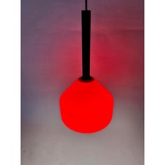 a red light that is on top of a black pole in the middle of a room