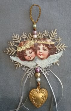 an ornament with two girls and a heart hanging from it's side