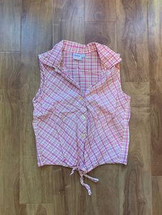 Vintage 90's 'Simply Basic' pink country chic tie waist blouse. Cropped, sleeveless, super cute little flower shaped buttons. Brand: Simply Basic Size: Tagged a Large - Fits more like a Small - all measurements from flat as per photos.  Top is in good vintage condition. * Please note that vintage items have been preowned and potentially preloved and are rarely 'Perfect.' I do my absolute best to source out amazing pieces that are in very good condition and thoroughly scan each item before postin 90s Style Sleeveless Vest For Spring, Cute Spring Sleeveless Vest, Cute Pink Vest Top, Pink Summer Tops With Buttons, Summer Pink Tops With Buttons, Y2k Collared Tops For Summer, Cute Fitted Sleeveless Blouse, Cute Sleeveless Summer Blouse, Y2k Style Tops With Buttons For Spring