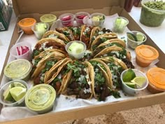 an open box filled with tacos and sauces