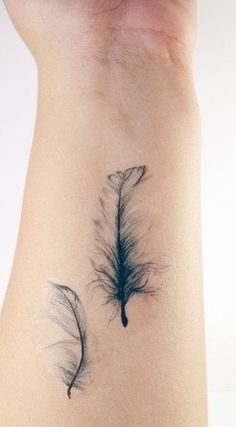 an image of a tattoo that is on someone's leg and it looks like feathers