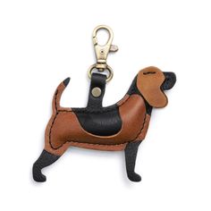 a brown and black dog shaped keychain with a leather tag hanging from it's side