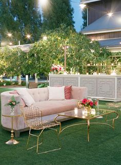 a couch and coffee table sitting on top of a grass covered field