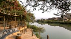 an outdoor seating area next to a body of water