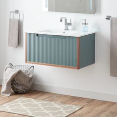 a bathroom with a sink, mirror and towel rack on the wall next to it