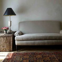 a white couch sitting next to a lamp on top of a table