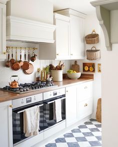 a kitchen with white cabinets and black and white checkered flooring on the walls