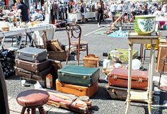 an outdoor flea market with lots of old suitcases