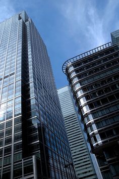 some very tall buildings in the city under a blue sky