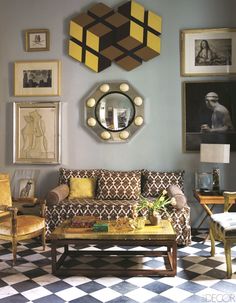 a living room filled with furniture and pictures on the wall next to a coffee table