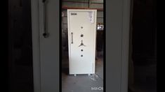 a large white locker sitting in the middle of a room with metal handles and knobs on it