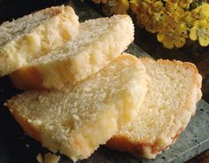 three pieces of bread sitting on top of a cutting board next to some yellow flowers