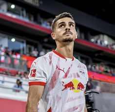 a man standing in front of a crowd at a sporting event with his head tilted to the side