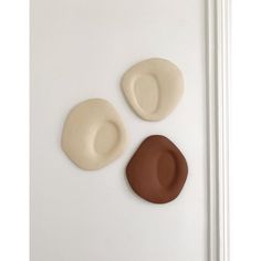 three different shapes of hats on a white wall