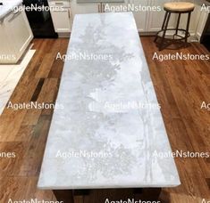 an image of a kitchen with white marble countertops and wood flooring in it