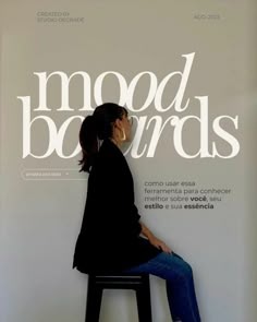 a woman sitting on top of a stool next to a white sign that says mood boards