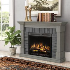 a fireplace in a living room with a painting on the wall and a potted plant next to it