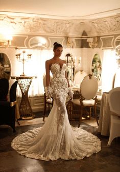 a woman in a wedding dress standing on the floor next to a chandelier