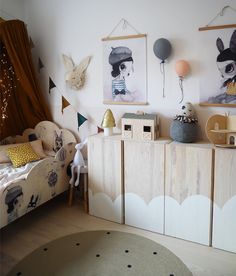 a child's bedroom decorated in white and wood with pictures on the wall above it