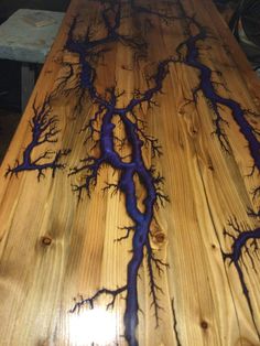 a wooden table with blue branches painted on it