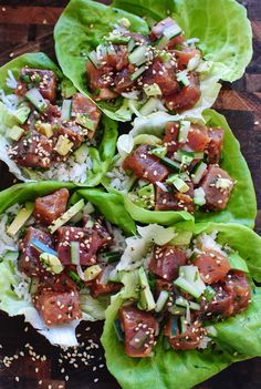 lettuce wraps filled with meat and veggies on top of a wooden table