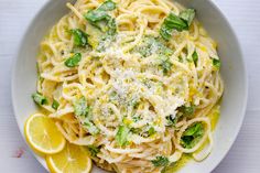 a white bowl filled with pasta covered in cheese and broccoli