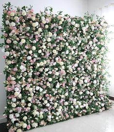 an artificial flower wall with pink and white flowers