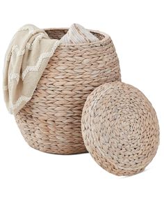 two woven baskets are sitting next to each other, one with a hat on top