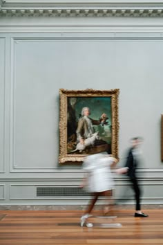 two people are walking in front of a painting