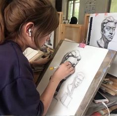 a woman is working on some drawings in an art studio with easel and pencils