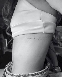 the back of a woman's stomach showing her lower body and arm with writing on it