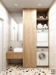 a washer and dryer in a bathroom with white tiles on the floor next to a sink