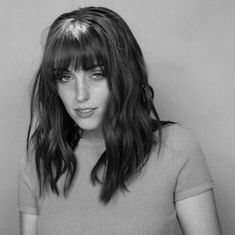 a black and white photo of a woman with bangs