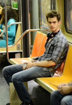 a young man sitting on a subway train