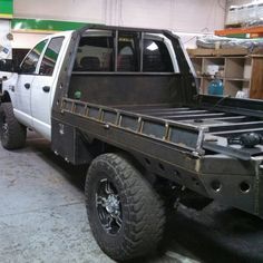 a white truck parked in a garage next to other vehicles