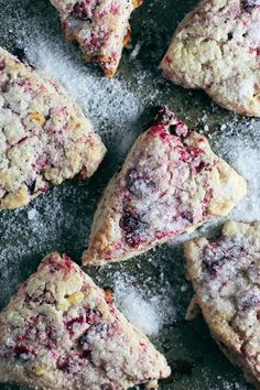 blueberry scones with powdered sugar are arranged on a gray surface, ready to be eaten