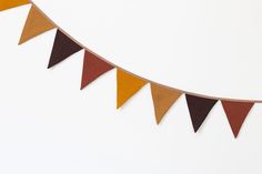 an orange, brown and yellow pennant hanging on a white wall