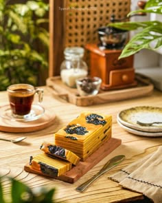 a table topped with slices of cake next to a cup of coffee