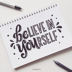 a notepad with the words believe in yourself written on it next to a pen