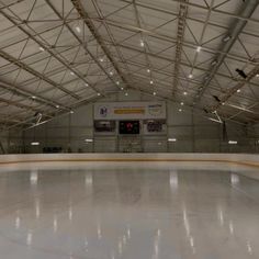 an indoor ice rink with lights on the ceiling