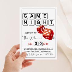 a person holding up a card that says game night with two dices on it