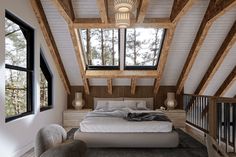 a bed sitting under a window in a bedroom next to a stair case and windows