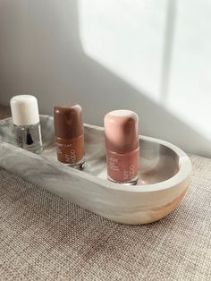 three nail polish bottles sitting on top of a tray